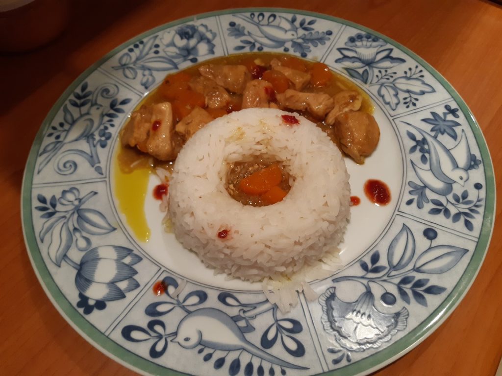 chicken with white rice and red yellow curry sauce