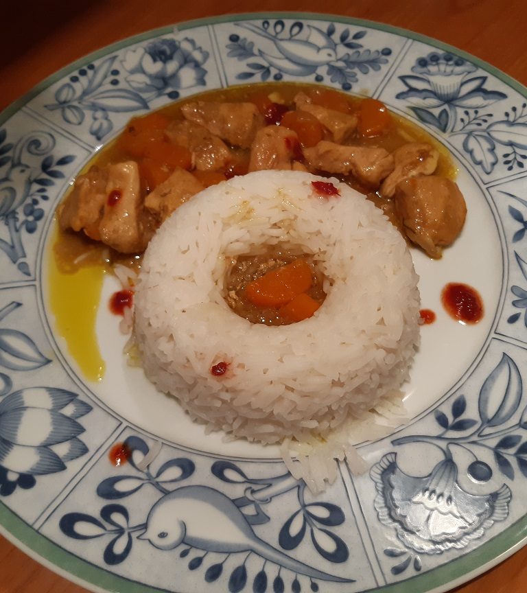 chicken with white rice and red yellow curry sauce