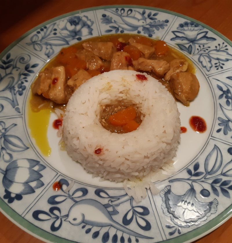 chicken with white rice and red yellow curry sauce