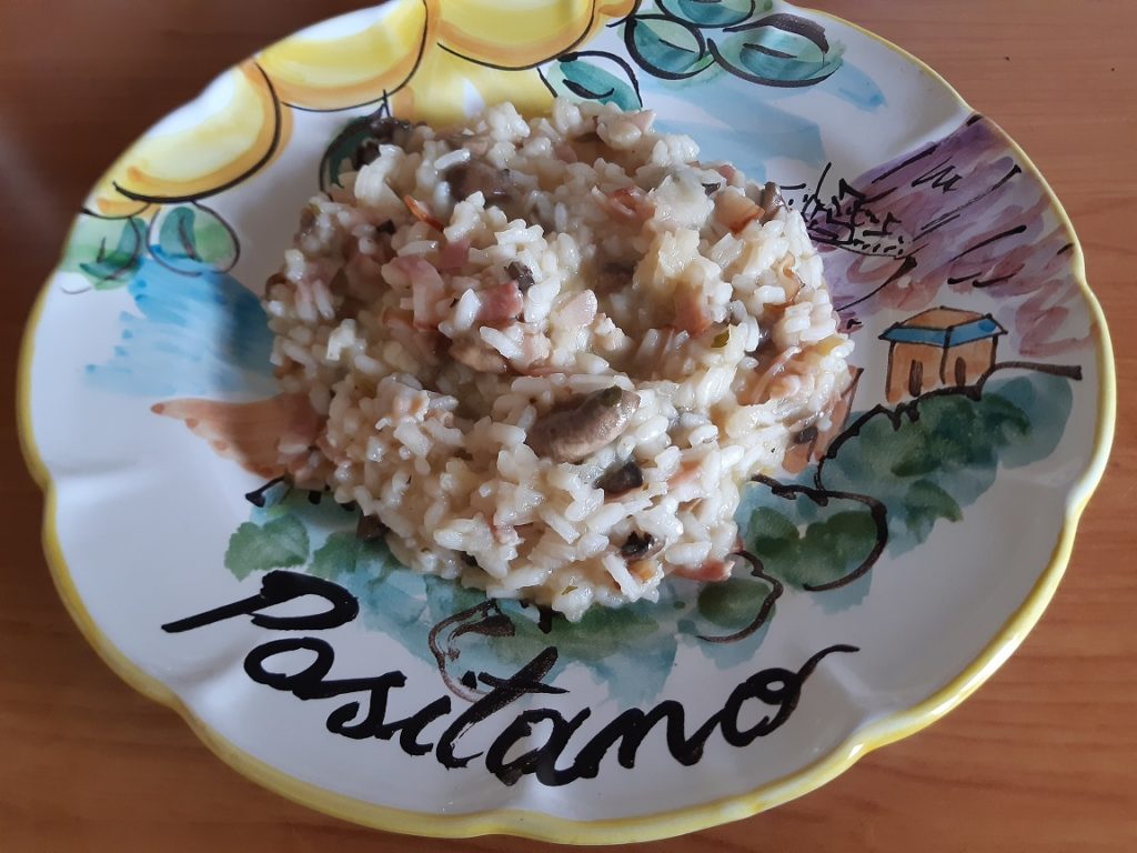 A risotto with mushrooms and bacon served in a ceramic dish from positano italy