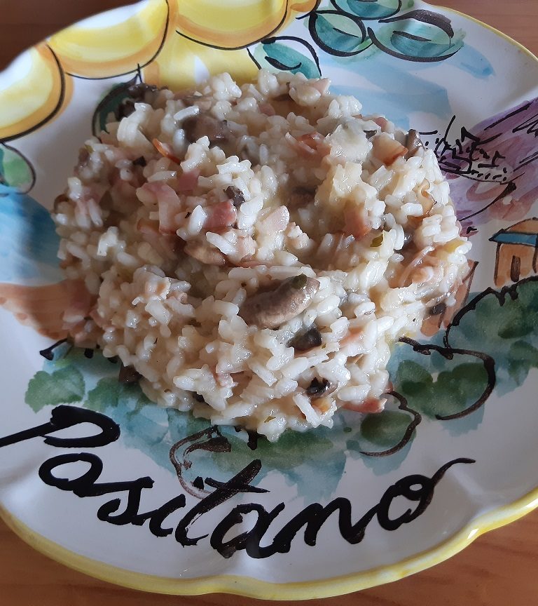 A risotto with mushrooms and bacon served in a ceramic dish from positano italy