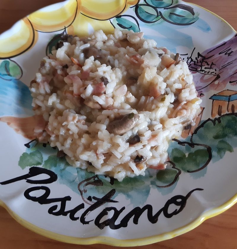 A risotto with mushrooms and bacon served in a ceramic dish from positano italy