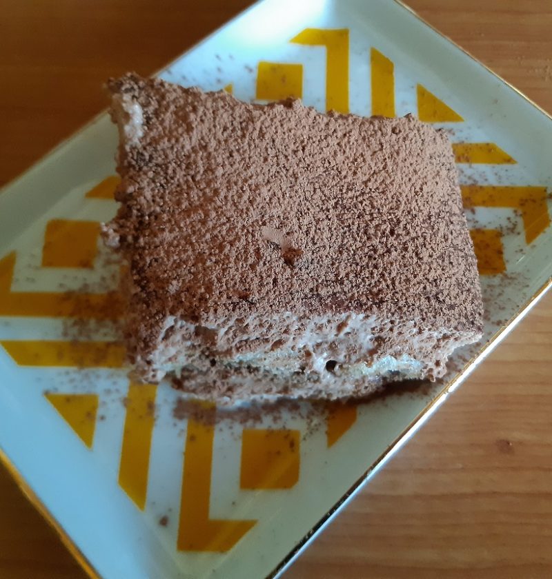A piece of tiramisu the italian dessert with cream cheese, nutella and biscuits with cocoa coating
