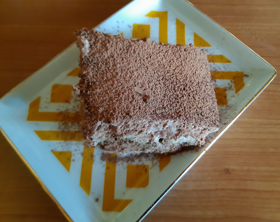 A piece of tiramisu the italian dessert with cream cheese, nutella and biscuits with cocoa coating