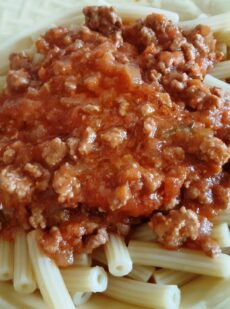 A dish with spaghetti and bolognese sauce with meat and tomato