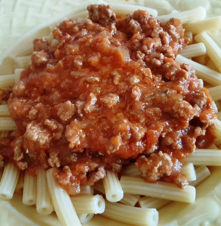 A dish with spaghetti and bolognese sauce with meat and tomato