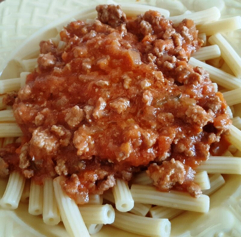 A dish with spaghetti and bolognese sauce with meat and tomato