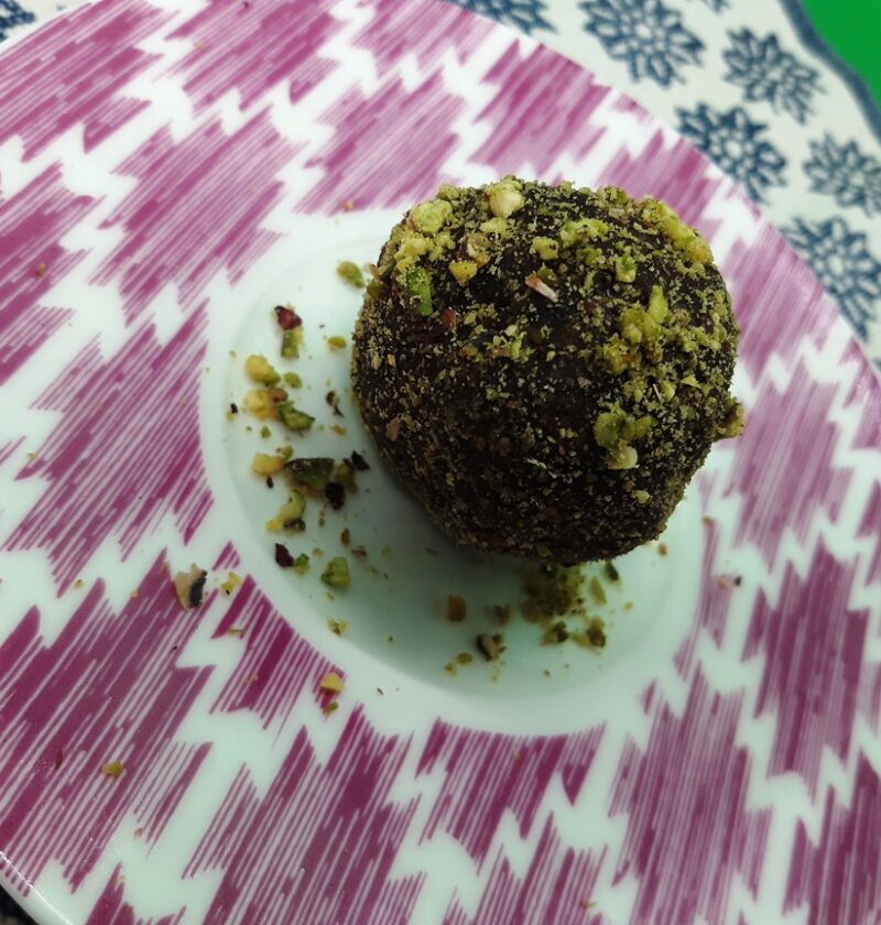 A dish with a chocolate pistacchio truffle