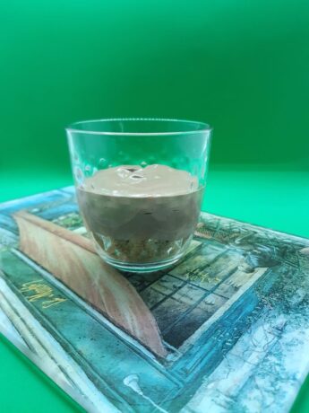 A glass containing chocolate mousse and biscuits