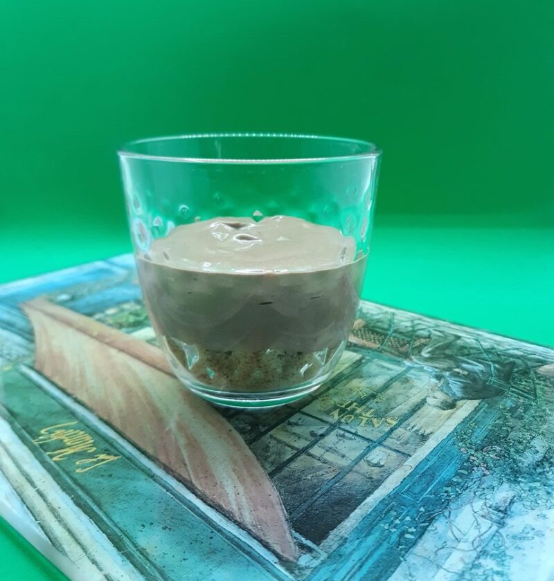 A glass containing chocolate mousse and biscuits