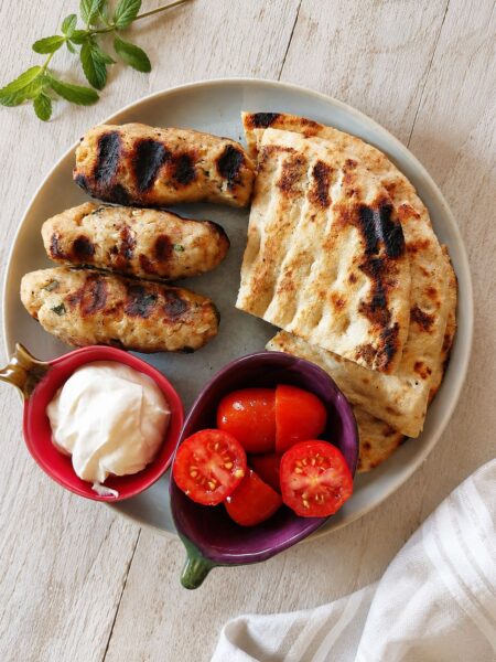 Juicy grilled chicken kebabs served with creamy Greek yogurt sauce, warm pita bread and fresh tomatoes.
