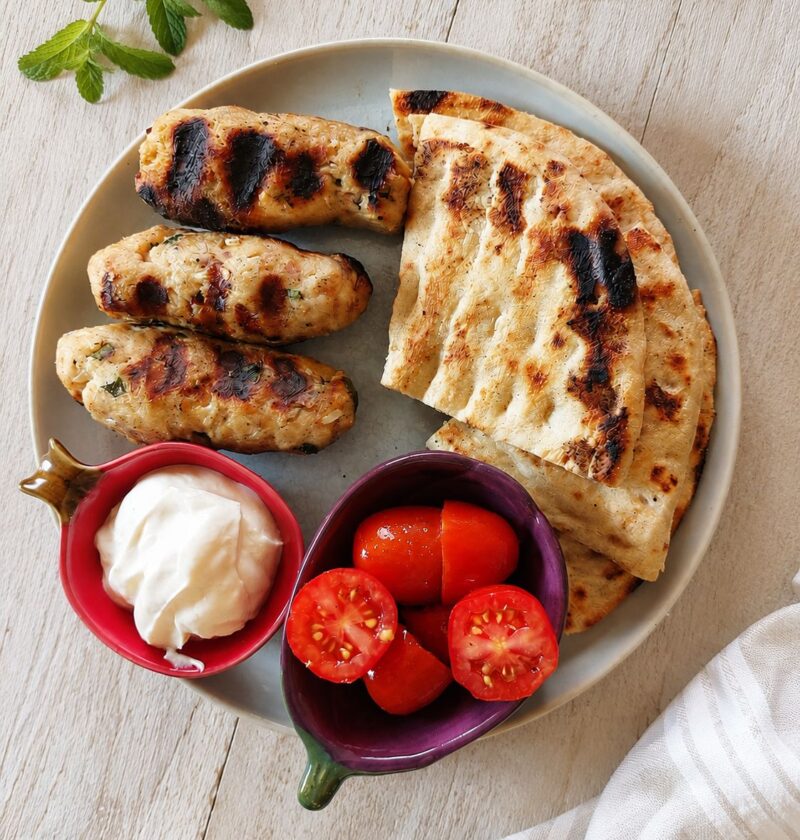 Juicy grilled chicken kebabs served with creamy Greek yogurt sauce, warm pita bread and fresh tomatoes.